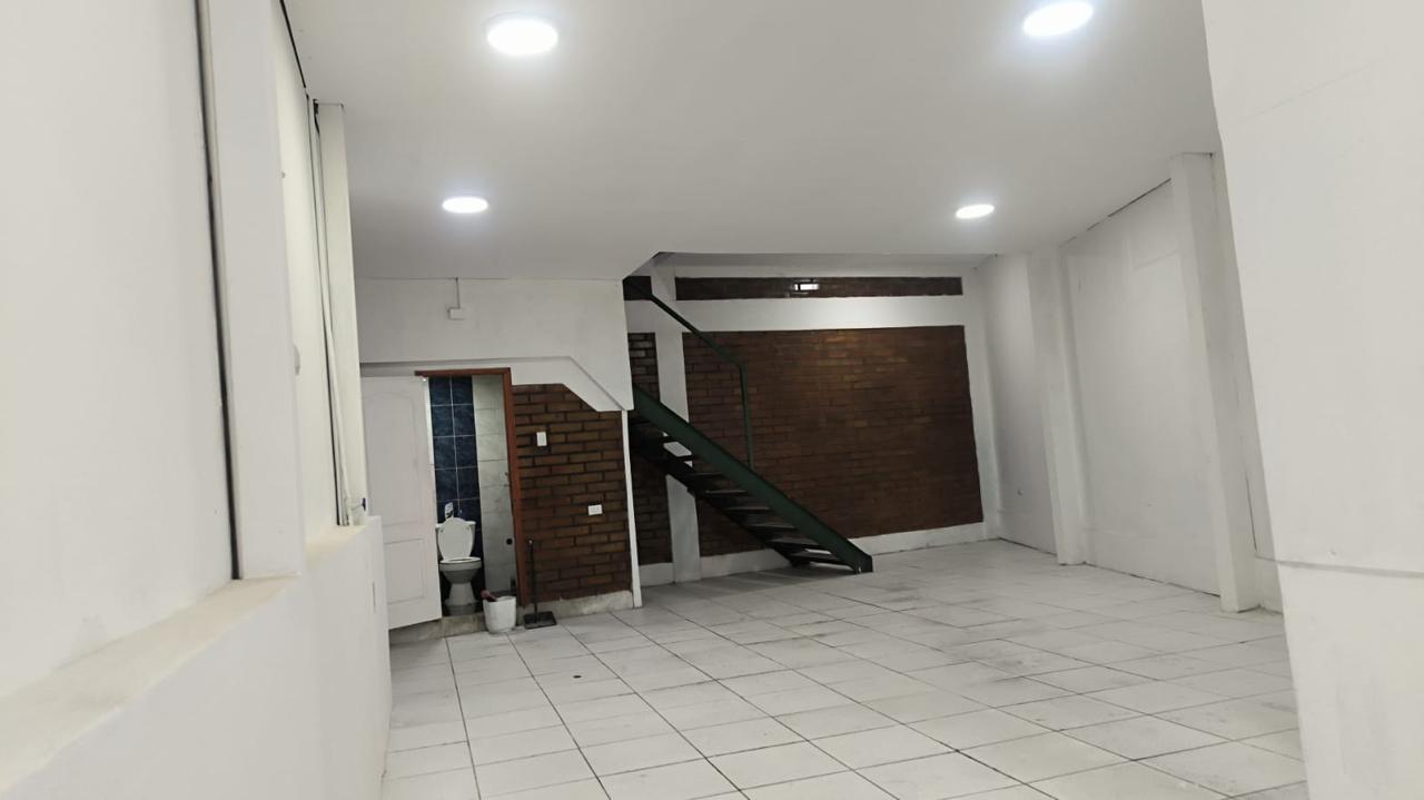 Vista interior de local comercial con escalera de acceso al altillo