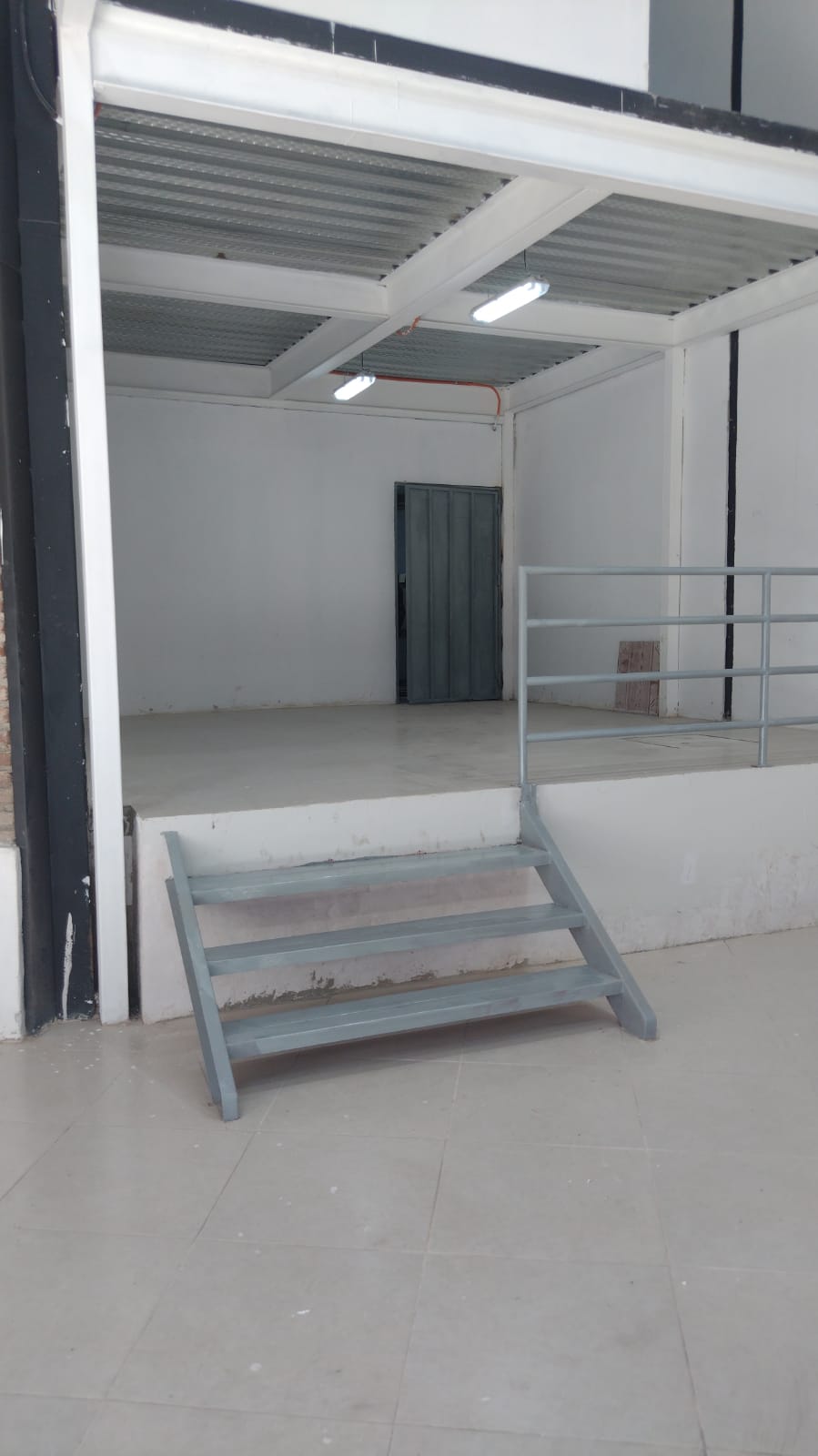 Escalera de acceso al mezzanine de local comercial