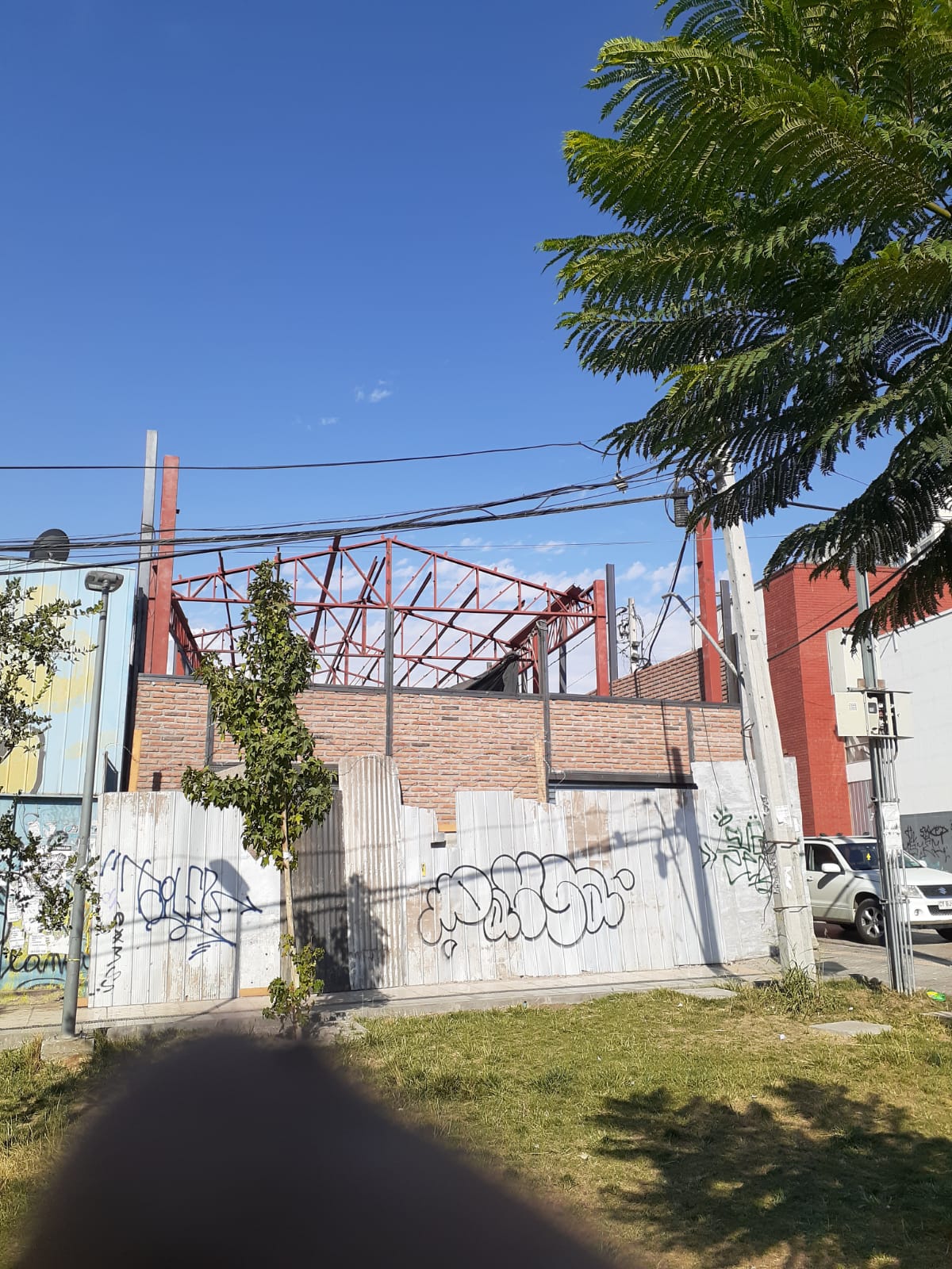 Estructura metálica de cubierta en montaje sobre muros de albañilería en Plaza Chacabuco