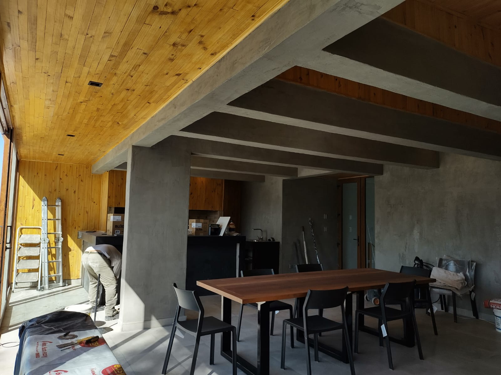 Quincho con estructura de hormigón y cielo de madera, comedor exterior