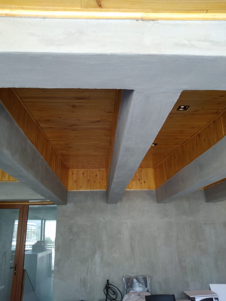 Detalle de cielo de madera y estructura de hormigón de quincho